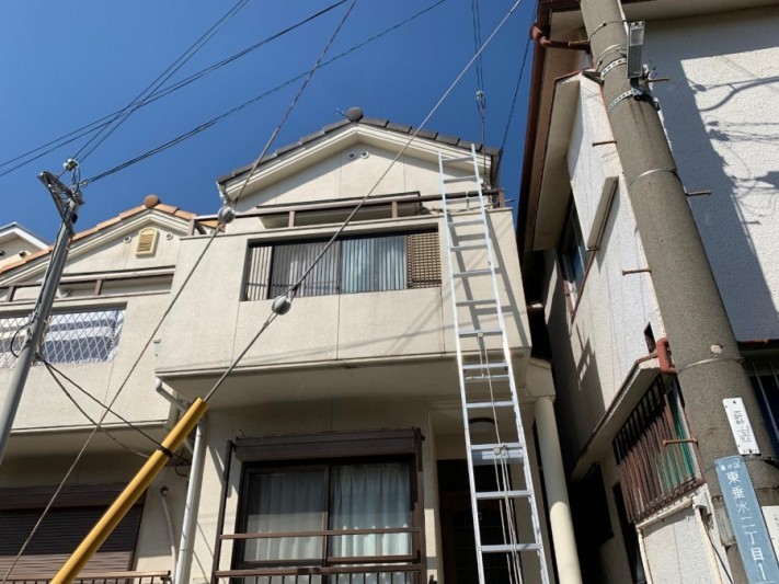 屋根に梯子を掛けている様子