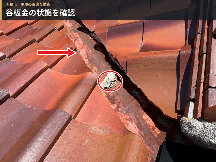 瓦屋根の谷板金に錆びや表面の傷みがあり堆積物が見られる様子