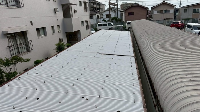 雹被害で穴のあいた駐輪場屋根