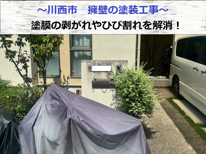 川西市で擁壁の塗膜や剥がれを解消する為部分塗装工事を行う現場の様子