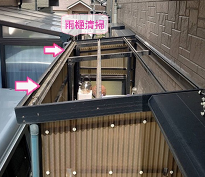 物置スペースの波形屋根張り直しで雨樋内部を清掃している様子