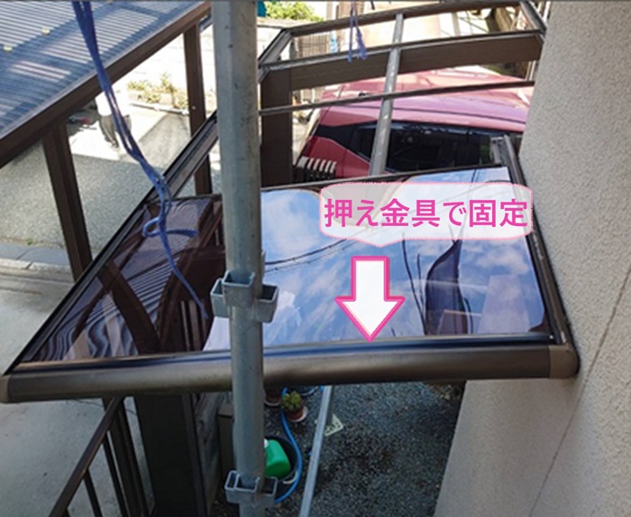 サイクルポート屋根交換でポリカーボネートを押え金具で固定している様子