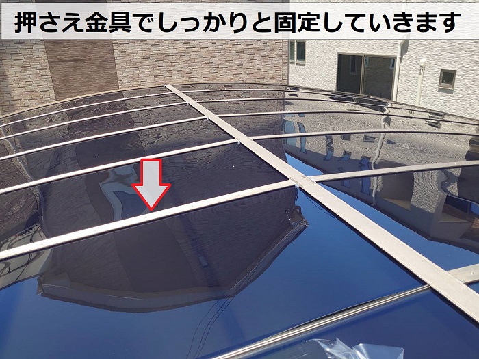 カーポート屋根のポリカーポネード板を押さえ金具で押さえている様子