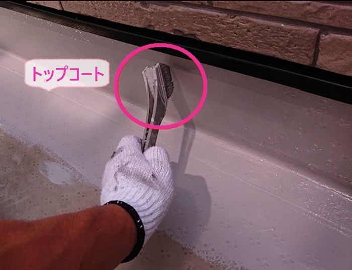 シート防水の補修工事でトップコートを塗っている様子