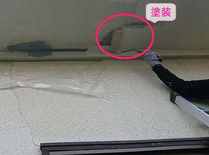 軒天の部分補修で仕上げの塗装をしている様子