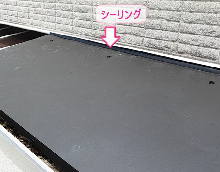 スレート庇の交換で壁際にシーリングを打設している様子