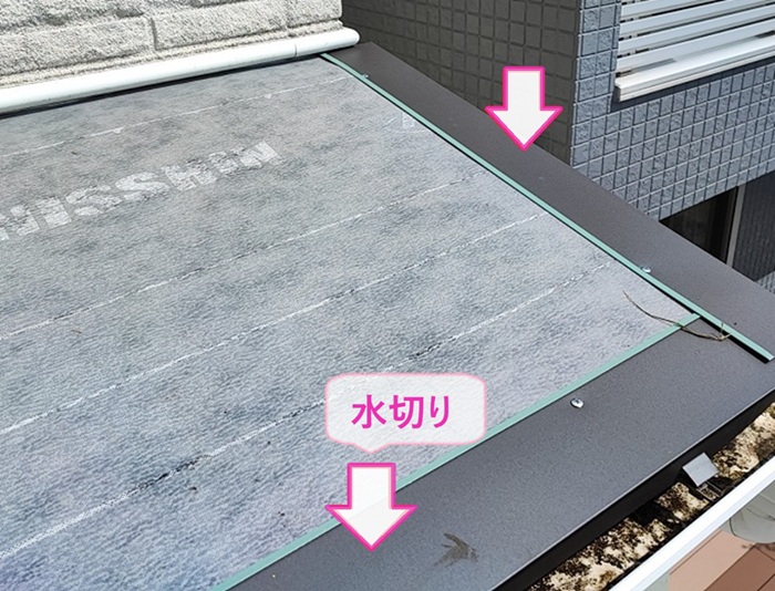スレート庇の交換で屋根の端部に水切りを取り付けている様子