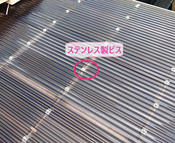 テラス屋根のポリカ板交換で新しいポリカ波板をステンレス製のビスで固定している様子