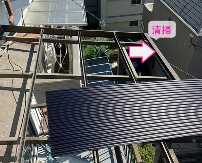 ベランダ屋根の破損修理で雨樋内部を清掃している様子