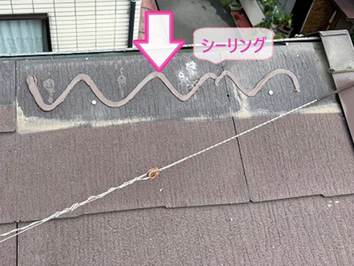 ３階建て住宅の部分補修で割れてるスレート屋根を撤去してシーリングを塗っている様子