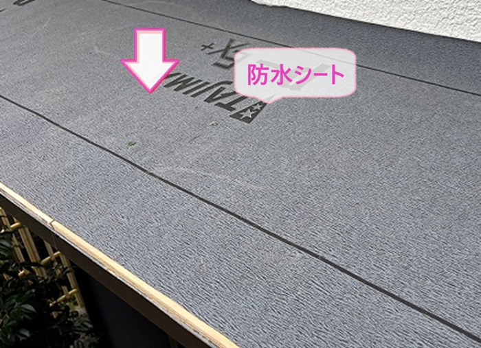 庇屋根の補修工事で防水シートを貼っている様子