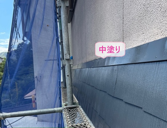 スレート庇の塗り替え工事で中塗りをしている様子