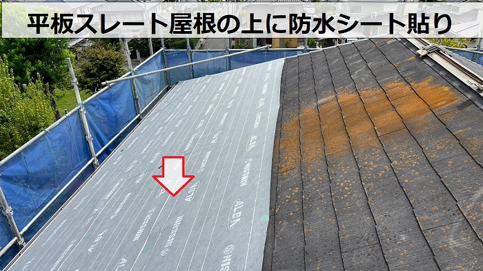 屋根カバー工事で平板スレート屋根の上に防水シートを貼ってる様子