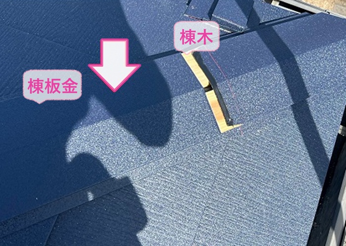 トップライトのあるスレート屋根の重ね張りで棟木と棟板金を取り付けている様子