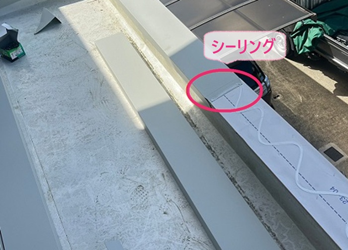庇の笠木修理でガルバリウム鋼板のジョイントにシーリングを挟み込んでいる様子