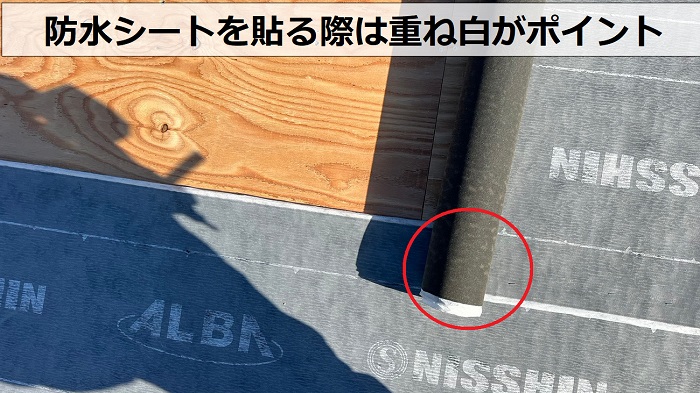 尼崎市での屋根葺き替え工事で防水シートの重ね白を紹介している様子