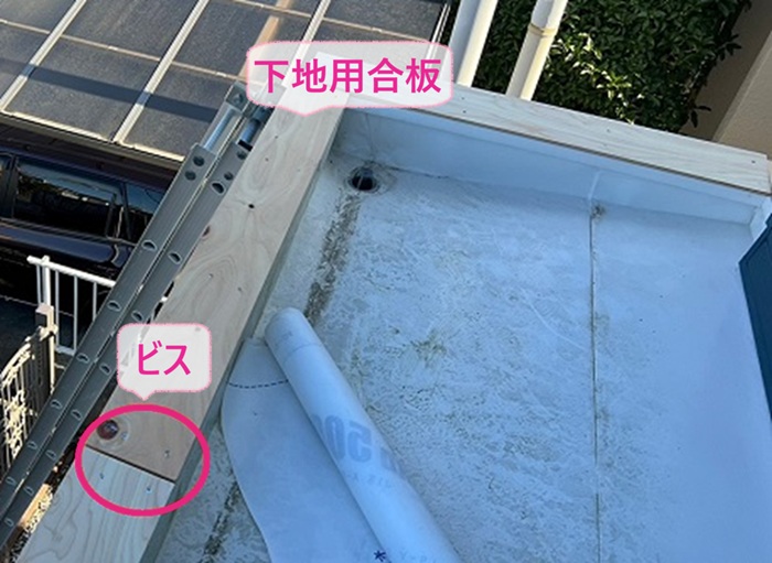 庇の笠木修理で下地用合板をビスで取り付けている様子