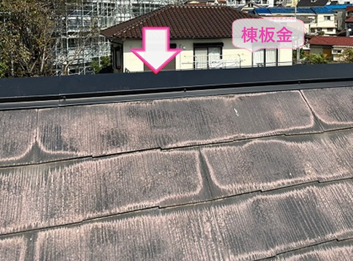 風害を受けた平型スレート屋根の局所補修で新しく棟板金を取り付けている様子