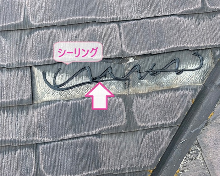 風害を受けた平型スレート屋根の局所補修で割れた屋根材を撤去してシーリングを塗っている様子