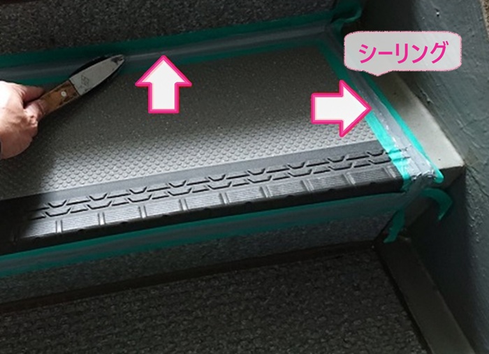 共用階段の部分修繕でステップシートの端部にシーリングを打設している様子