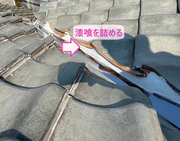 瓦屋根の谷部のリニューアル工事で谷板と瓦屋根の隙間に漆喰を詰めている様子