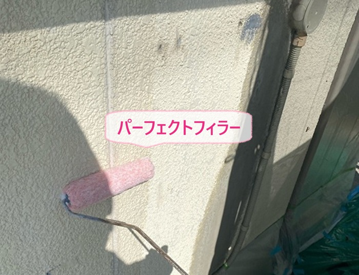 外壁塗装工事で下塗り材のパーフェクトフィラーを塗っている様子