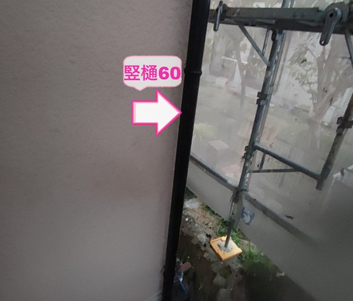 外装補修の雨樋交換で新しい竪樋を取り付けている様子