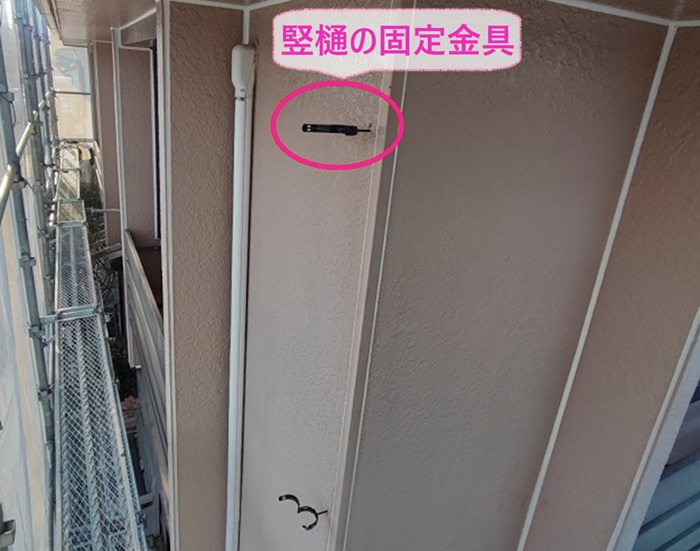 外装補修の雨樋交換で竪樋の固定金具を取り替えている様子