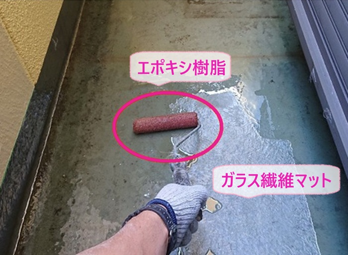 バルコニー防水工事でガラス繊維マットを敷いてエポキシ樹脂を塗っている様子
