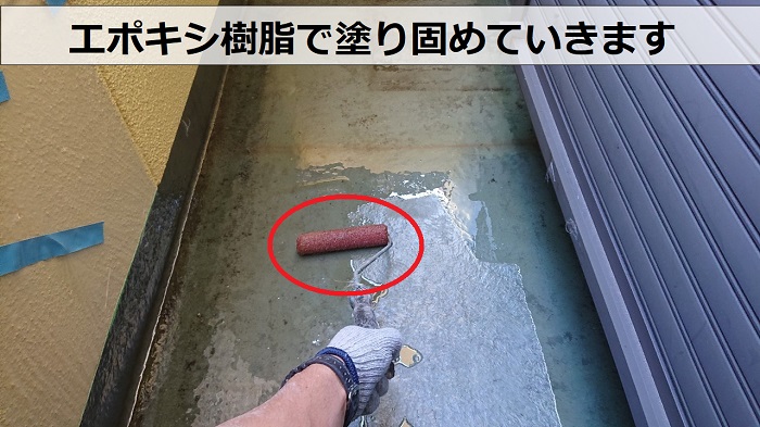 尼崎市でのベランダＦＲＰ防水工事でガラス繊維のマットをエポキシ樹脂で塗り固めている様子