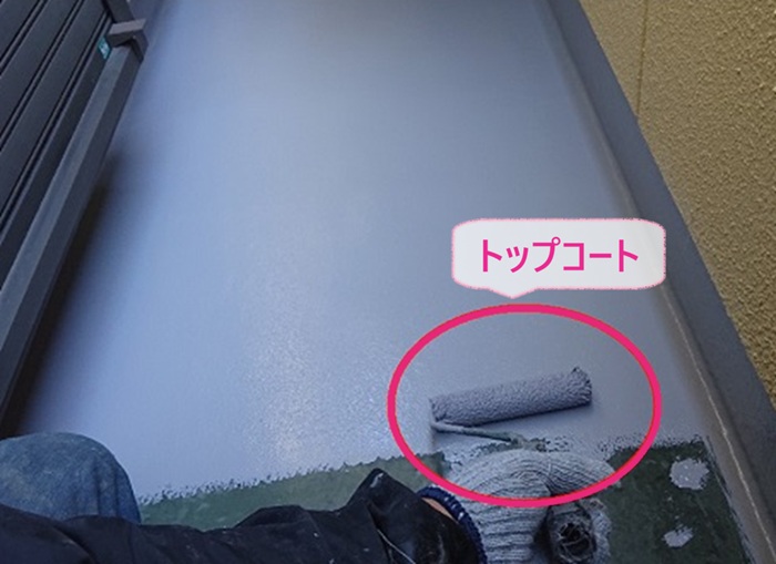バルコニーのFRP防水工事でトップコートを塗っている様子