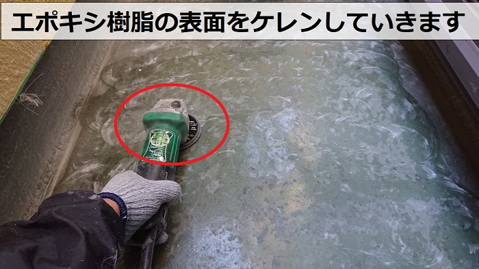 尼崎市でのベランダＦＲＰ防水工事でエポキシ樹脂の表面をケレンしている様子