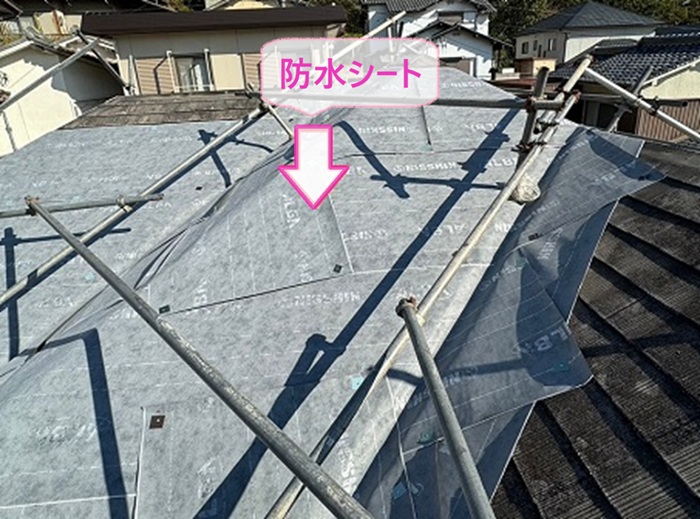 スレート屋根の重ね葺き工事で防水シートを貼っている様子