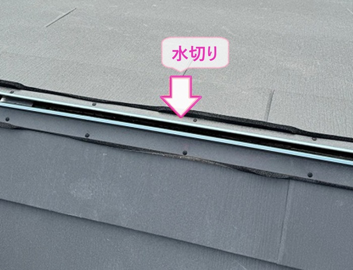 スレート屋根の重ね葺き工事で屋根に開口を開けて水切りを取り付けている様子