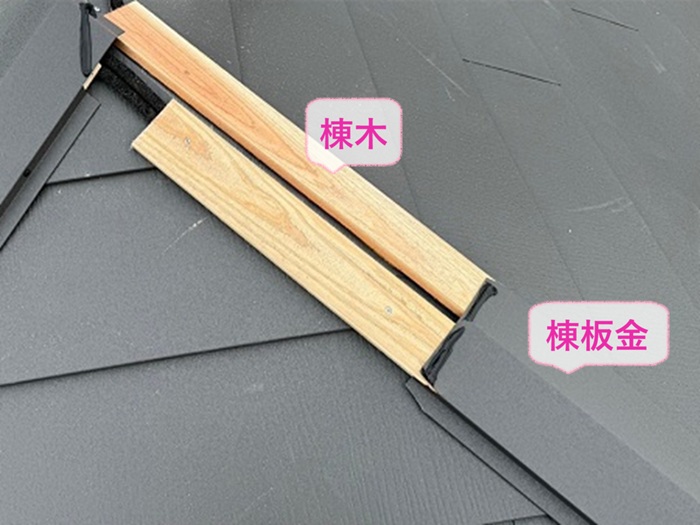 スレート屋根の重ね葺き工事の仕上げに棟木と棟板金を取り付けている様子