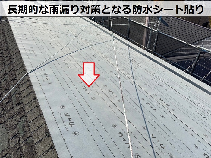 RC造のアスファルトシングル屋根へ重ね葺き工事をしている中で防水シートを貼っている様子