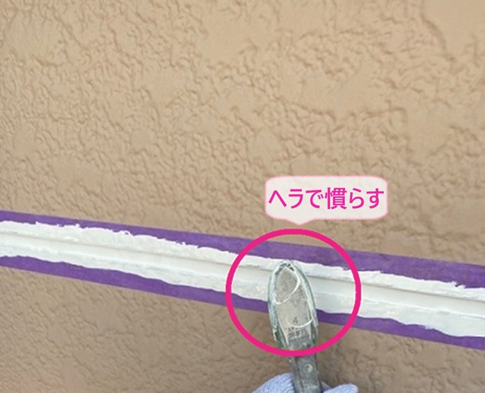 外壁目地の補修でシーリングをヘラでキレイに慣らしている様子