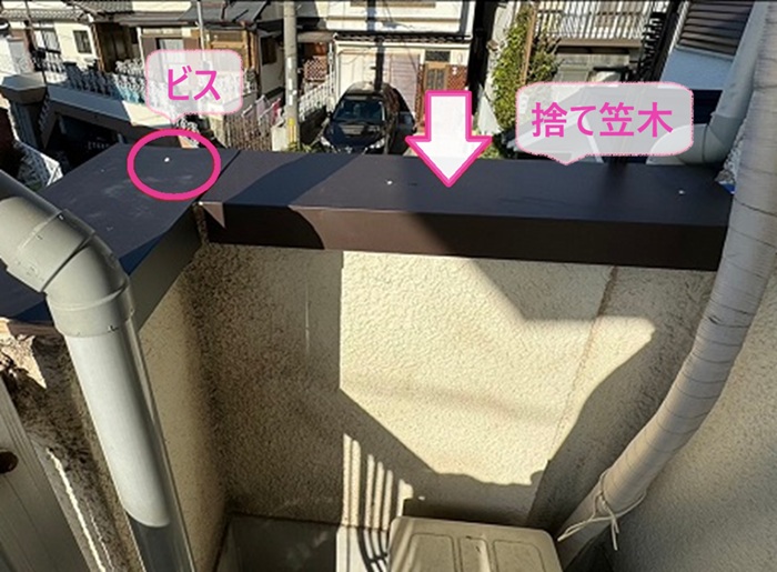 笠木の板金交換で捨て笠木をビスで固定している様子