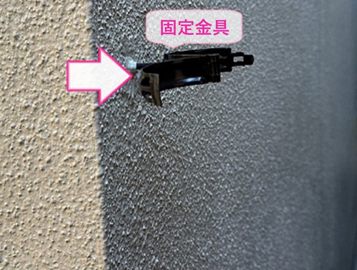 雨樋改修工事で竪樋の新しい固定金具を取り付けている様子