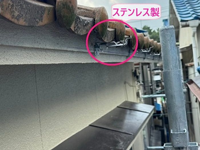 雨樋改修工事でステンレス製の新しい固定金具を取り付けている様子