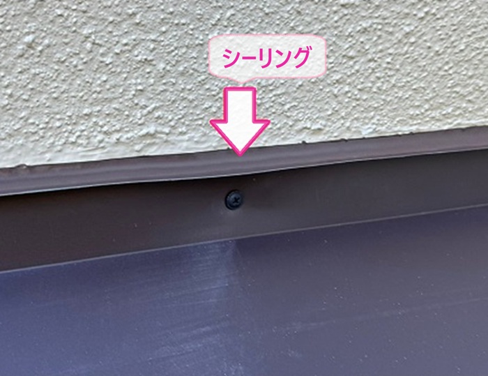 金属屋根改修で壁際にシーリングを打設して止水処理をしている様子