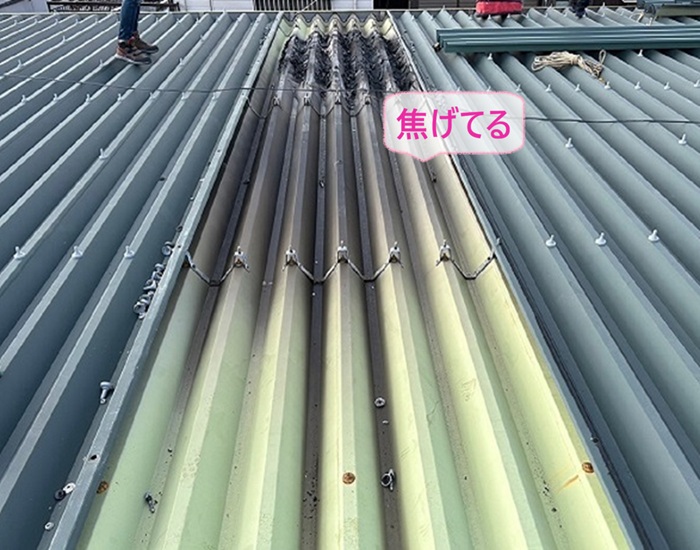 火災被害を受けた集合住宅屋根の部分修理で２重屋根の下の部分も焦げている様子