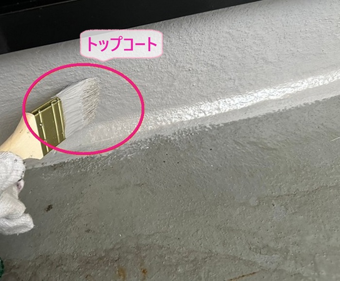 FRP防水の再トップコート施工で立ち上がり部分からトップコートを塗っている様子