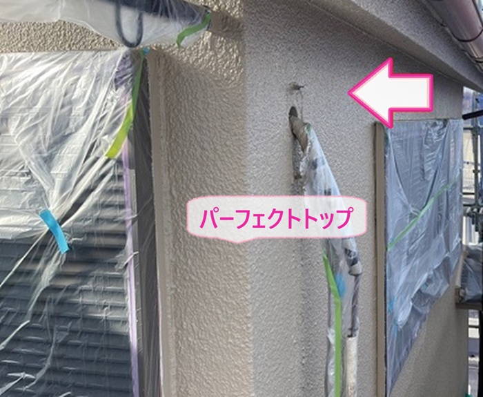リシン外壁の高耐久塗装でパーフェクトトップを塗っている様子