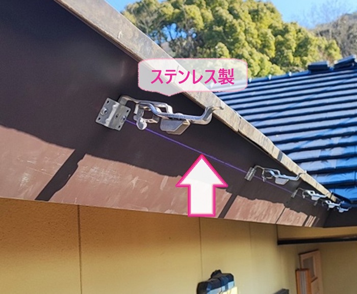 雨樋補修で新しいステンレス製の固定金具を取り付けている様子