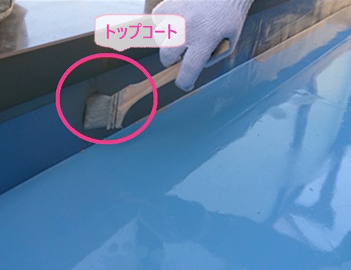 ベランダ床防水リフォームでトップコートを塗っている様子