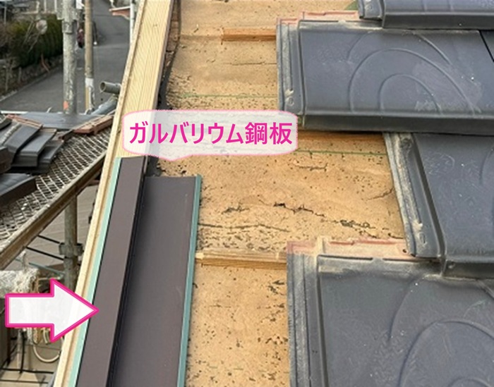 瓦屋根の漏水対策でガルバリウム鋼板製の水切りを取り付けている様子