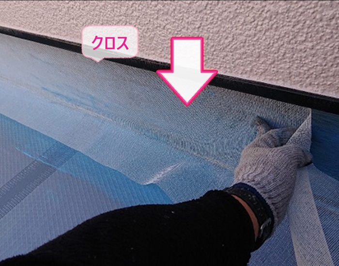陸屋根の防水改修で立ち上がり部分にクロスを貼っている様子