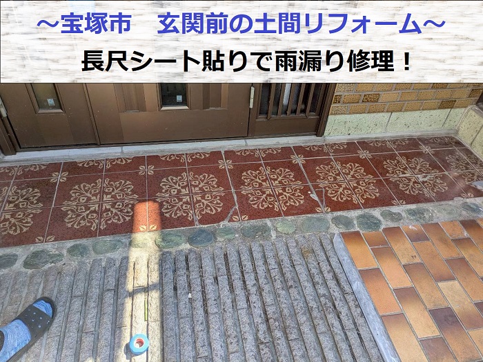 宝塚市で玄関前の土間リフォームとして長尺シートを貼り雨漏り修理する現場の様子