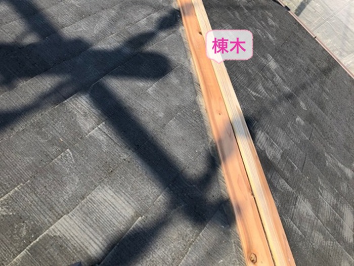 3階建て平型スレート屋根の補修工事で新しい棟木を取り付けている様子